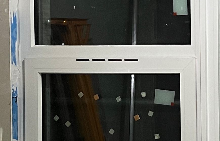 The vent itself: four slots through the top rail of the sash