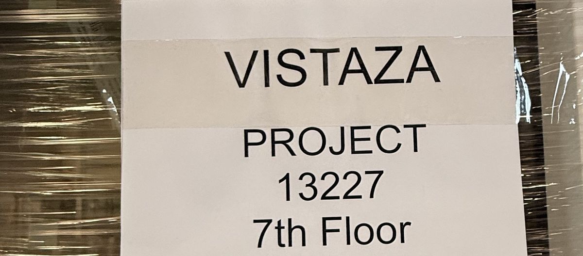 A printed sign on a wrapped rack: Vistaza, the project number and 7th Floor