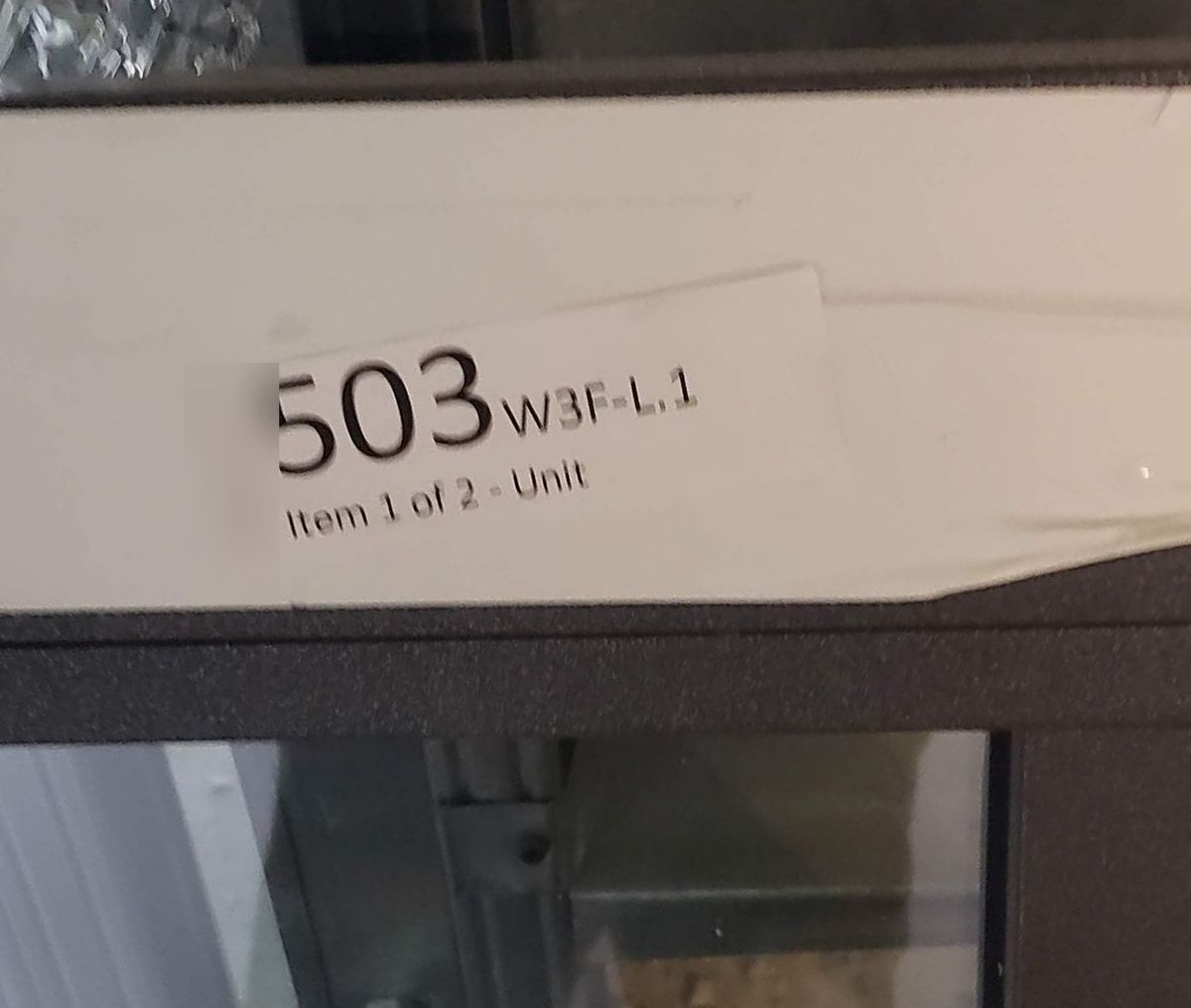 A sticker on a window frame reading 503, W3F-L.1, Item 1 of 2 - Unit