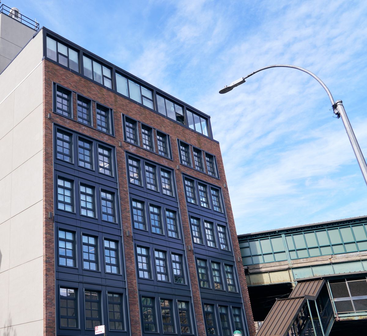 A Vistaza building beside an elevated train line