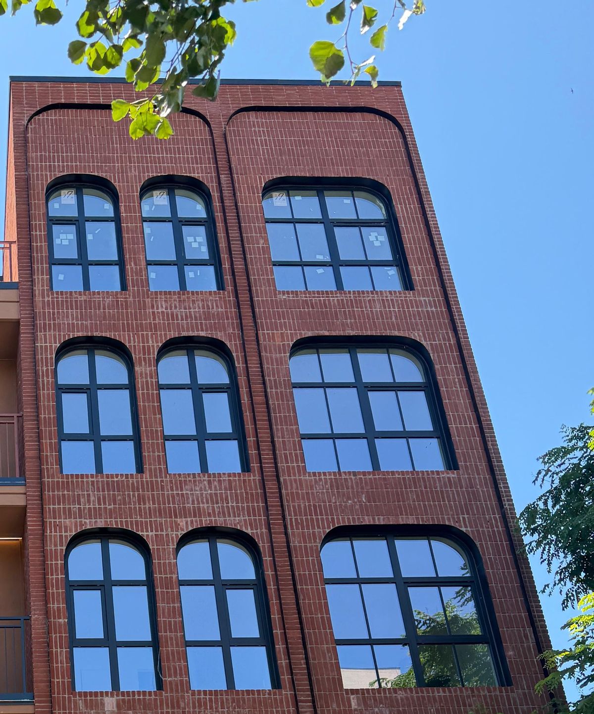 The same arched bay, three floors of round-top windows