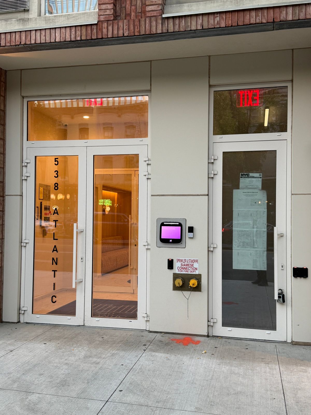 Atlantic: the lobby entrance at street level, a pair of doors and an exit door, each under a glass transom