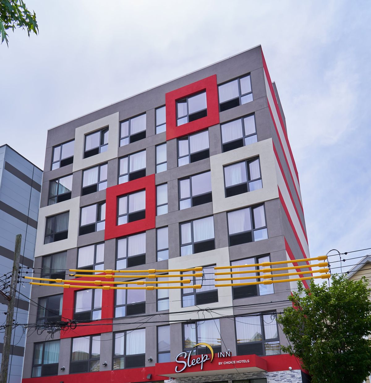 A hotel with a panel facade and red window surrounds