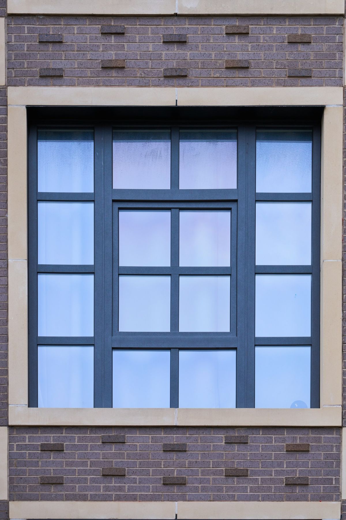 One Vistaza window in a pale stone surround, its glass divided into twelve lights by black bars