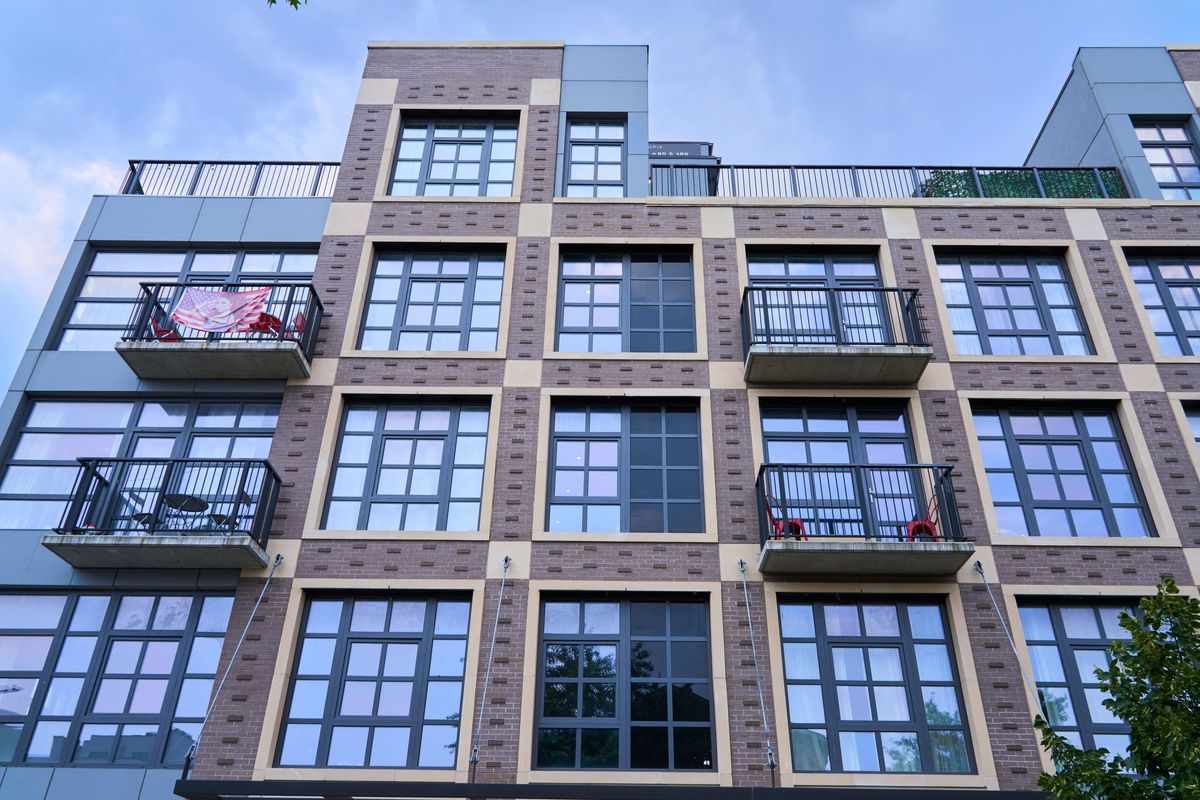 A column of black spandrel glass between clear windows on a brick facade