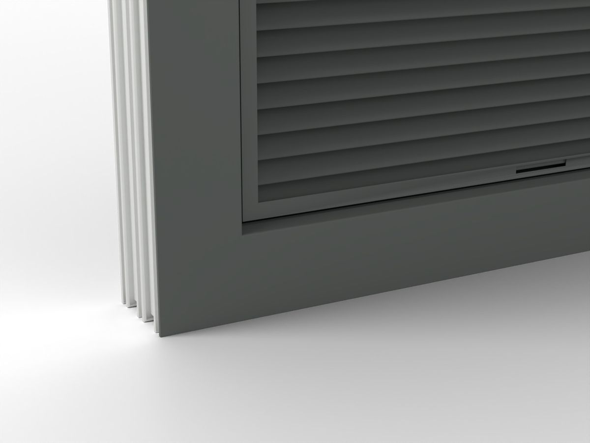 The bottom corner of a gray louver in its window frame, with a weep slot in the sill channel under the blades